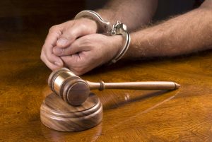 Battery Photo of shackled hands next to a hammer and gavel