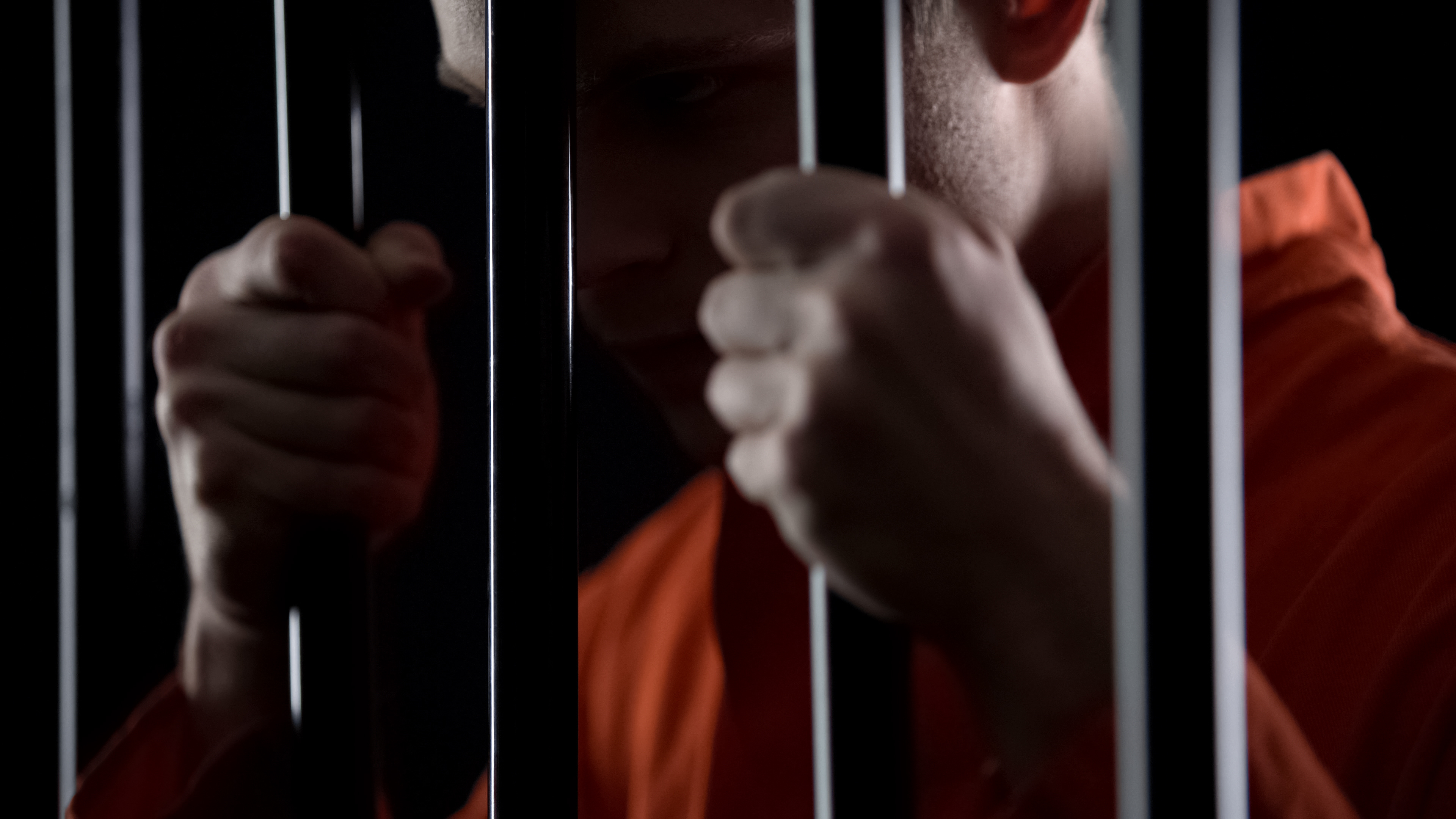 Man in jail behind cell bars - Chicago Criminal Defense Attorney