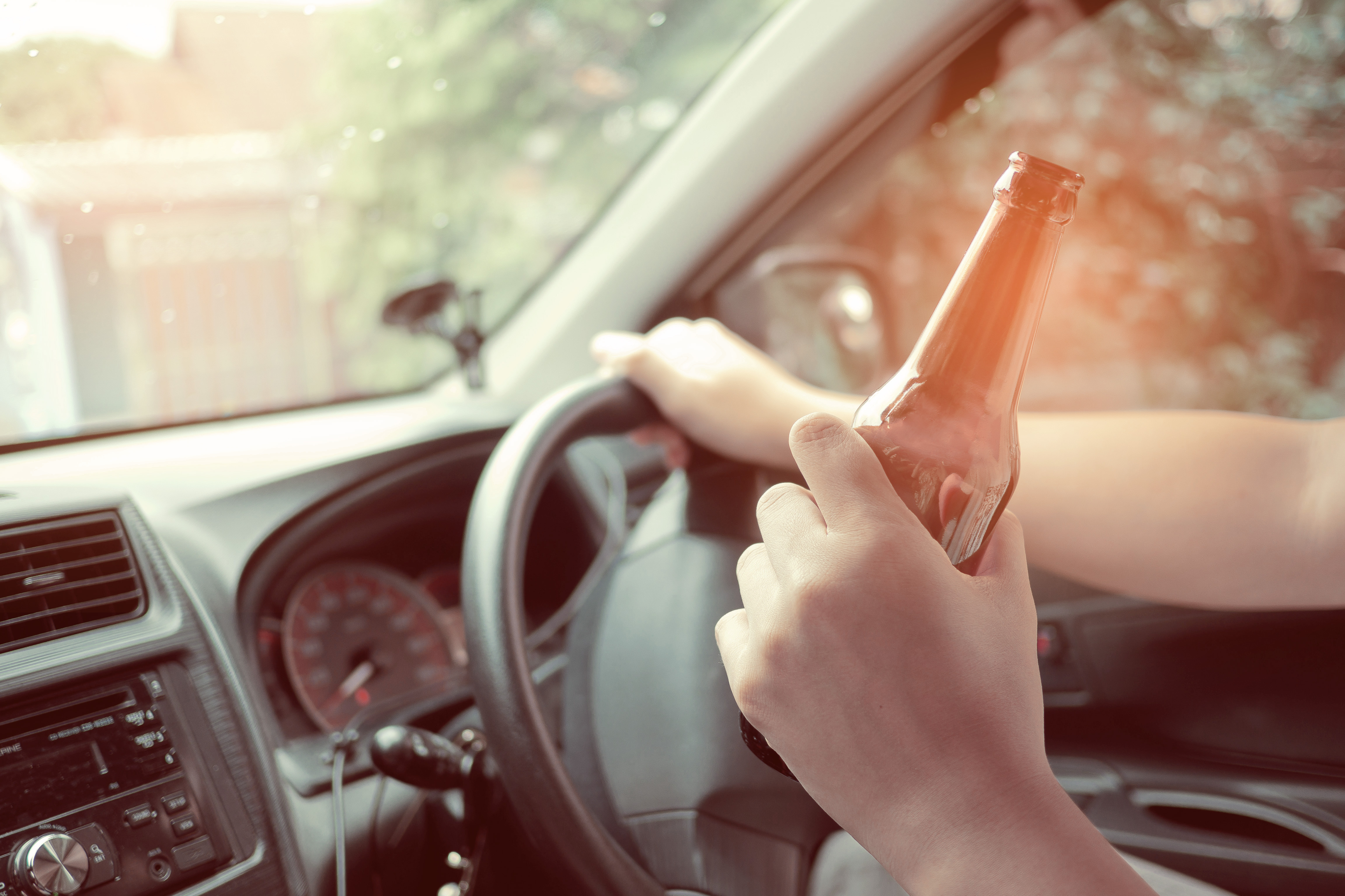 DUI defense lawyers - a person drinking alcohol inside the car driving - Purav Bhatt 