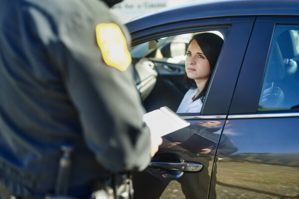 Writing, woman and traffic officer with ticket for checkpoint, security and crime investigation on highway. Policeman, law and driver registration for car accident, dui or road safety with suspect.
