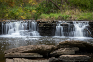 Beautiful fall leaves surround waterfall runoff at Waterfall Glen Forest Preserve, Dupage County, IL. Beautiful nature photo of a cascading waterfall